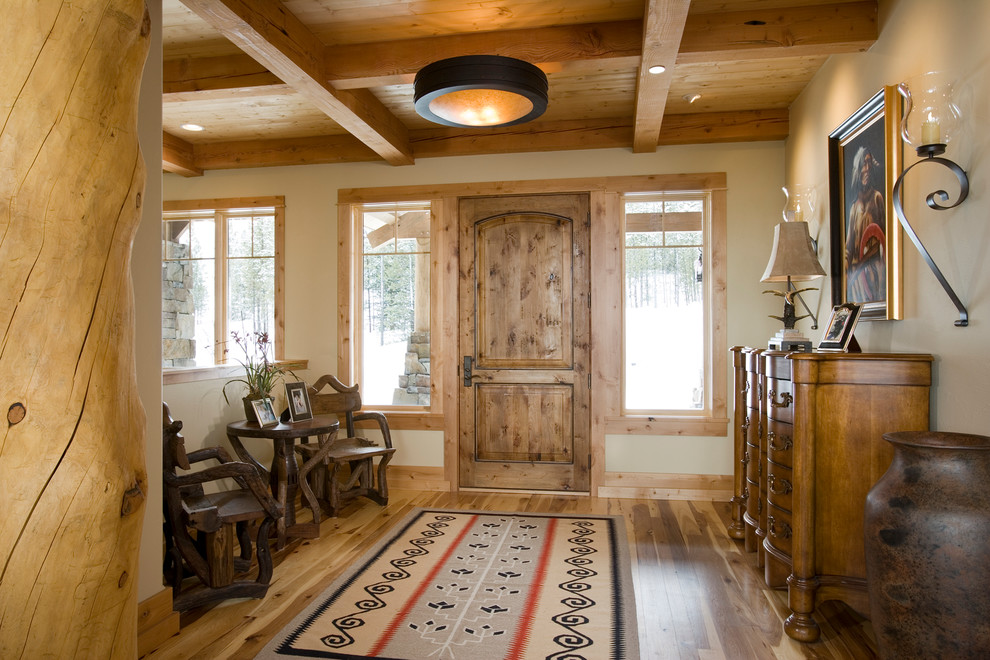 Großes Uriges Foyer mit beiger Wandfarbe, hellem Holzboden, Einzeltür, brauner Haustür und braunem Boden in Sonstige