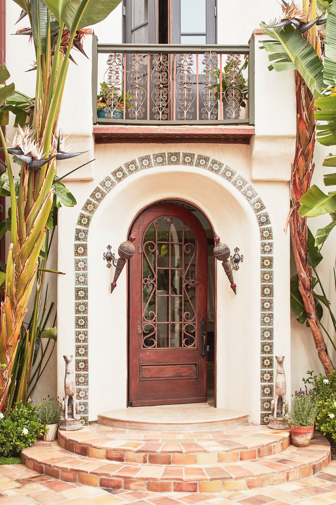 Imagen de puerta principal mediterránea de tamaño medio con puerta simple, puerta de madera oscura y paredes blancas