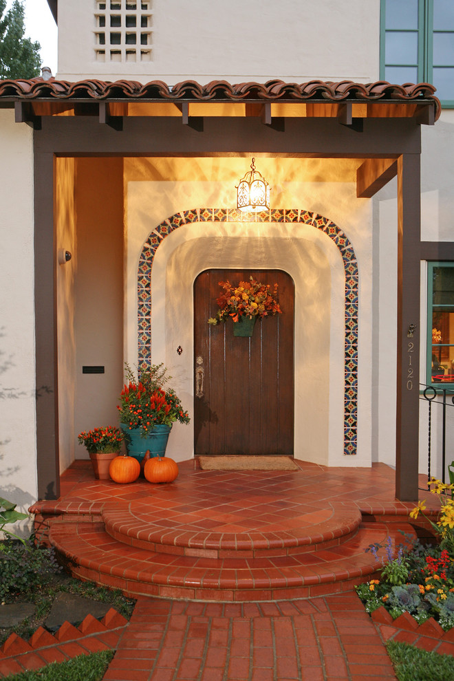 Imagen de puerta principal mediterránea de tamaño medio con puerta simple, paredes blancas y puerta de madera oscura