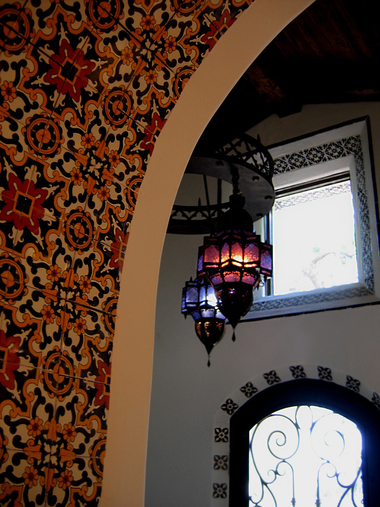 Inspiration pour un hall d'entrée méditerranéen de taille moyenne avec un mur blanc, une porte simple, tomettes au sol, une porte noire et un sol rouge.