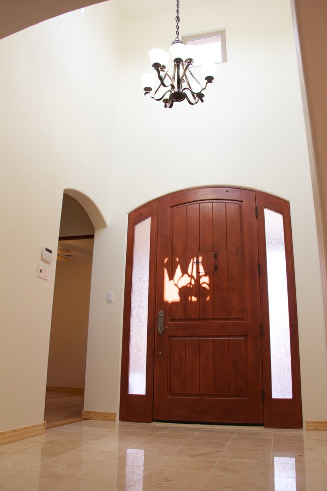 На фото: фойе среднего размера в средиземноморском стиле с белыми стенами, мраморным полом, одностворчатой входной дверью и входной дверью из темного дерева