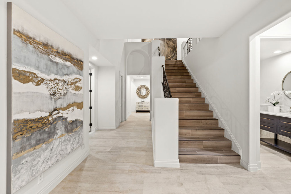 Esempio di un grande ingresso eclettico con pareti bianche, pavimento in marmo, una porta a due ante, una porta marrone, pavimento bianco e soffitto a volta