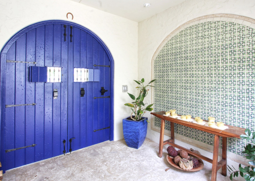 Idee per un grande corridoio con pareti beige, pavimento in travertino, una porta a due ante, una porta blu e pavimento beige