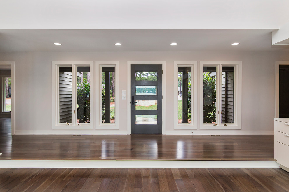 Moderne Haustür mit weißer Wandfarbe, hellem Holzboden, Einzeltür und grauer Haustür in Charlotte