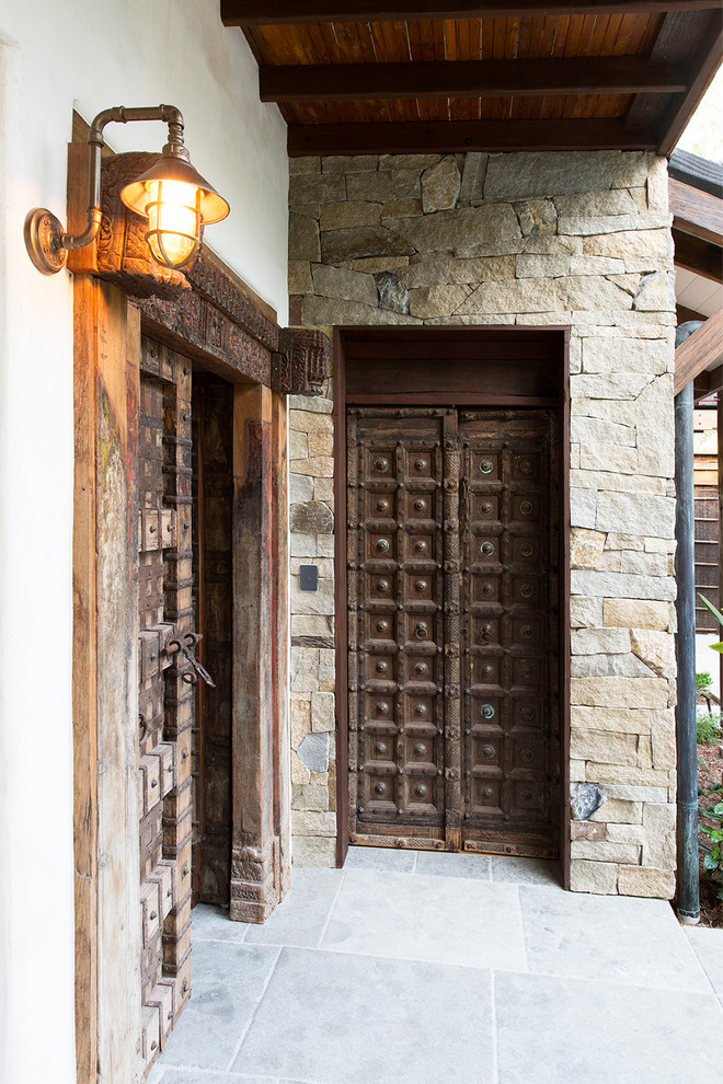 ケアンズにあるトロピカルスタイルのおしゃれな玄関ドア (白い壁、濃色木目調のドア、グレーの床) の写真