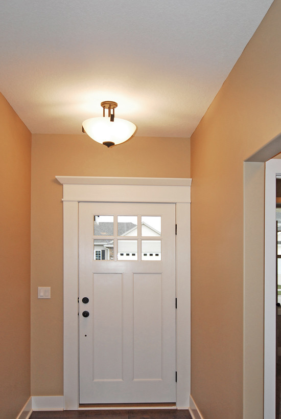 Exemple d'une petite porte d'entrée craftsman avec un mur beige, une porte simple, une porte blanche et parquet foncé.