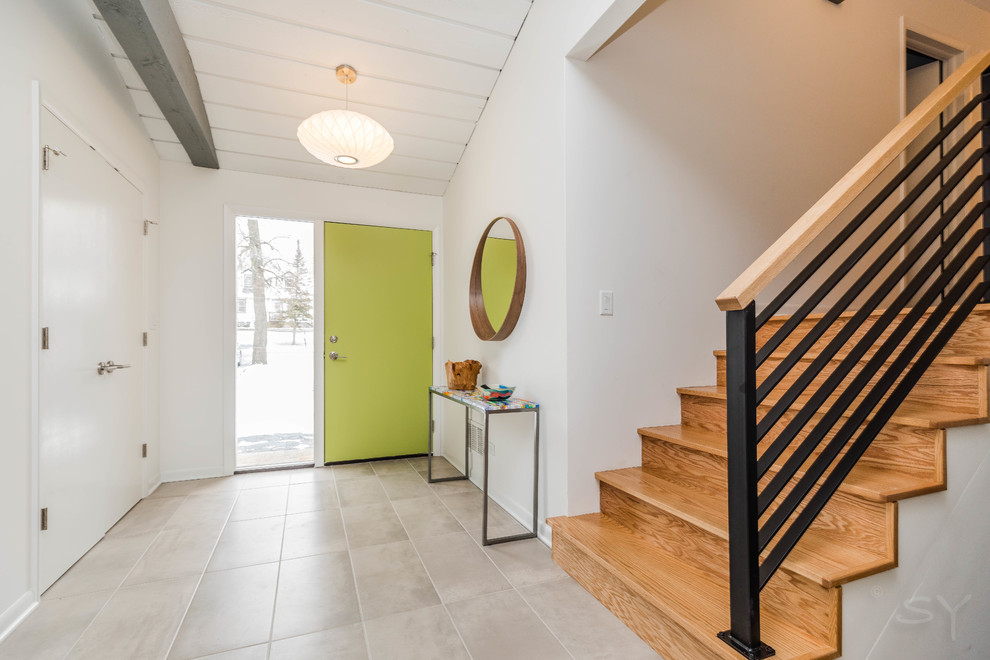 Diseño de entrada retro con paredes blancas, suelo de baldosas de porcelana, puerta simple, puerta verde y suelo gris