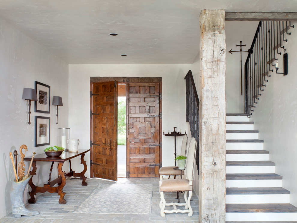 Example of a mountain style brick floor entryway design in Other with a medium wood front door and white walls