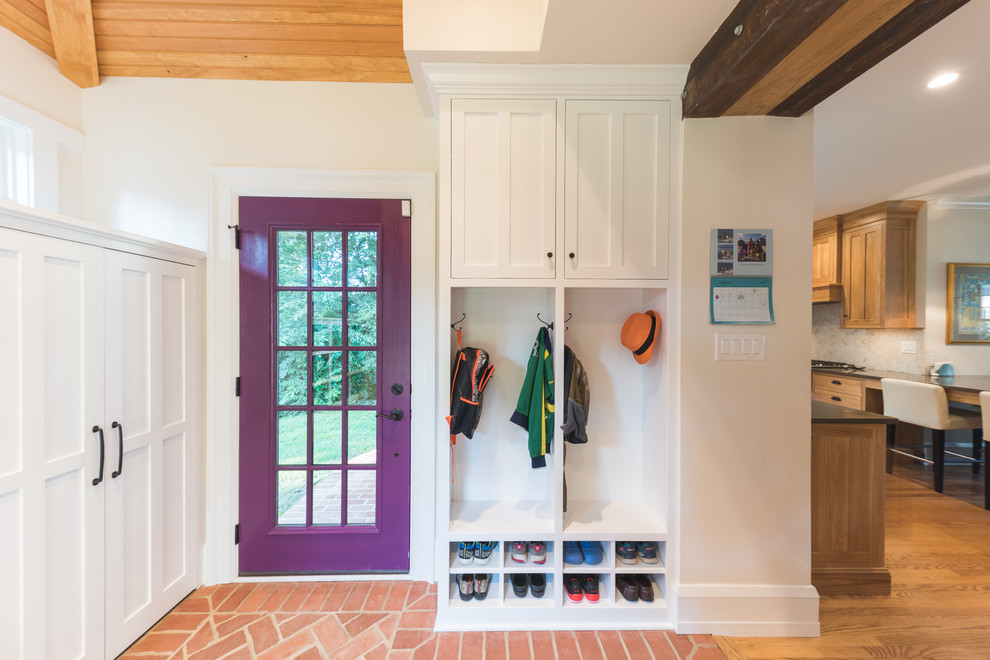 Пример оригинального дизайна: тамбур со шкафом для обуви в классическом стиле с белыми стенами, кирпичным полом, одностворчатой входной дверью, фиолетовой входной дверью и красным полом