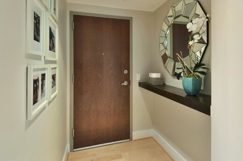 Exemple d'une petite entrée chic avec un couloir, un mur beige, parquet clair, une porte simple et une porte marron.