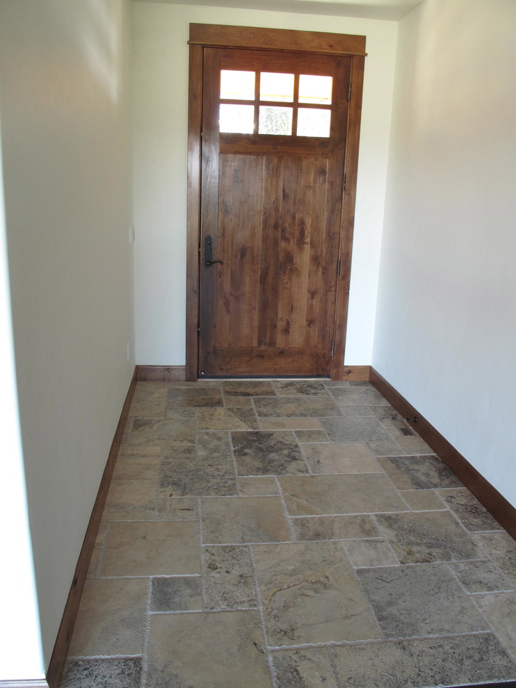 Cette image montre une porte d'entrée craftsman de taille moyenne avec un mur blanc, un sol en travertin, une porte simple et une porte en bois foncé.