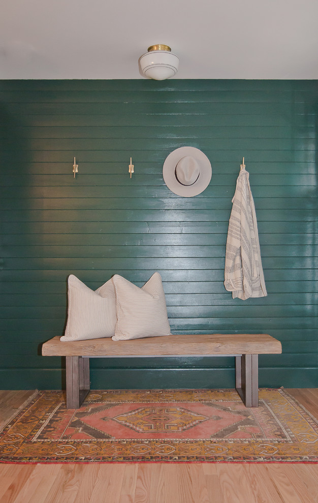 他の地域にあるお手頃価格の小さなトランジショナルスタイルのおしゃれな玄関ロビー (緑の壁、淡色無垢フローリング、黒いドア、茶色い床) の写真