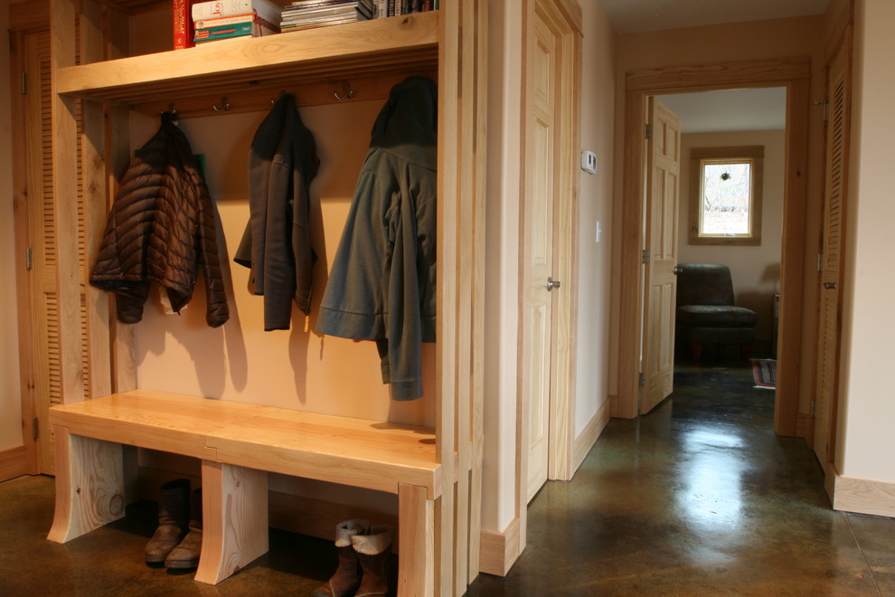 На фото: тамбур среднего размера со шкафом для обуви в стиле рустика с бежевыми стенами, бетонным полом и коричневым полом с