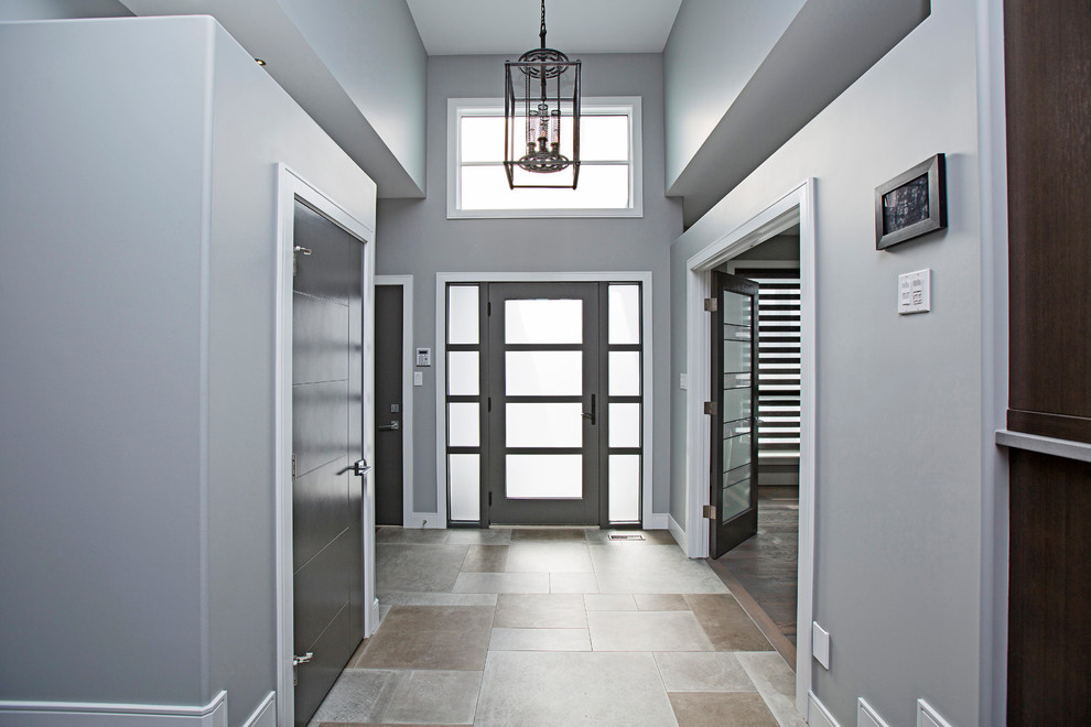 Modelo de distribuidor moderno de tamaño medio con paredes grises, suelo de baldosas de porcelana, puerta simple, puerta gris y suelo gris