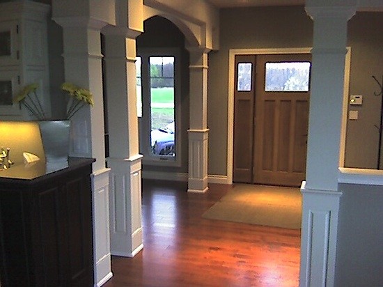 Idee per un ingresso classico di medie dimensioni con pareti marroni, parquet scuro, una porta singola, una porta in legno scuro e pavimento marrone