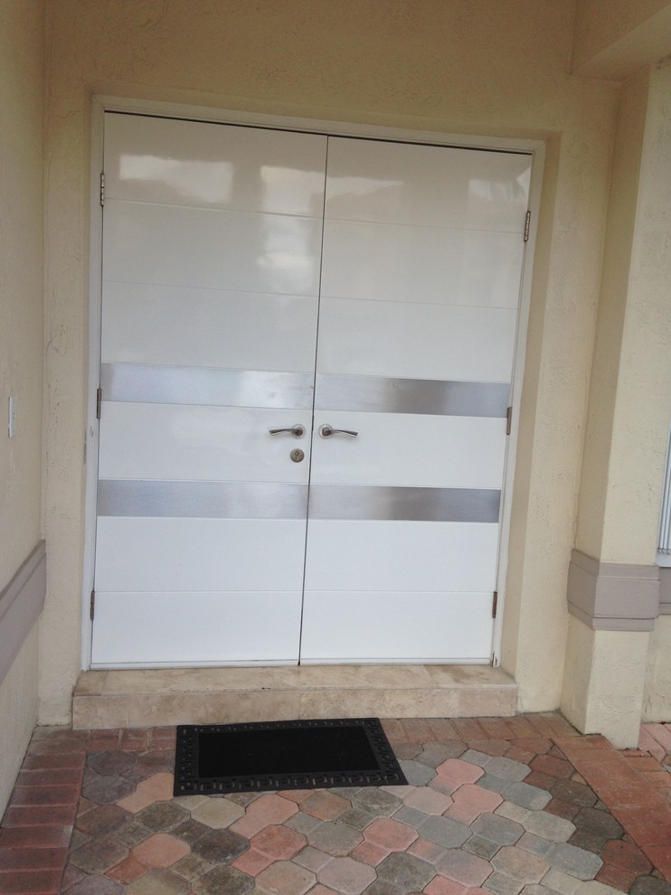 This is an example of a mediterranean front door in Miami with a double front door and a white front door.