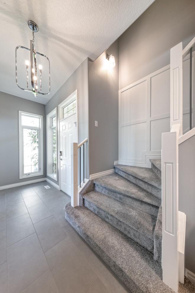 Mittelgroßes Klassisches Foyer mit grauer Wandfarbe, Keramikboden, Einzeltür, weißer Haustür, grauem Boden und vertäfelten Wänden in Edmonton
