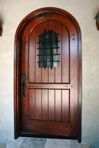 Aménagement d'une porte d'entrée montagne avec un mur beige, un sol en carrelage de porcelaine, une porte simple, une porte en bois foncé et un sol beige.