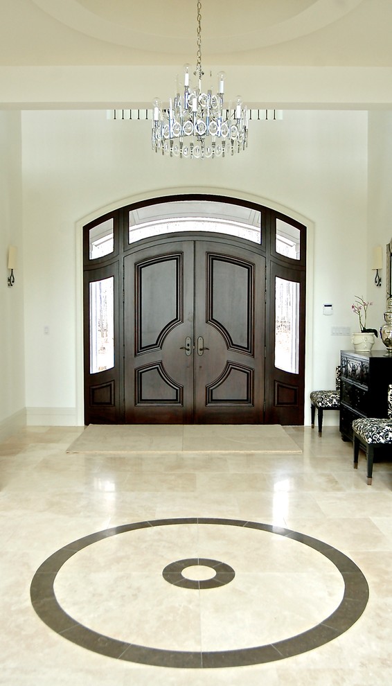 トロントにあるラグジュアリーな巨大なトランジショナルスタイルのおしゃれな玄関ロビー (白い壁、ライムストーンの床、濃色木目調のドア) の写真