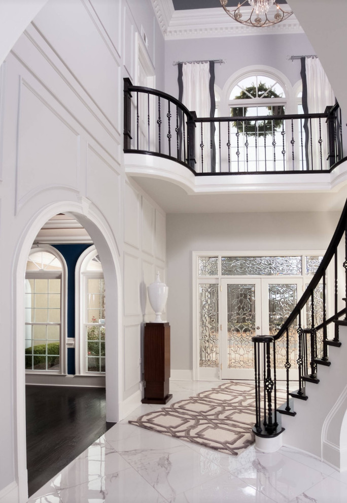 Großes Klassisches Foyer mit grauer Wandfarbe, Marmorboden, Doppeltür, Haustür aus Glas, weißem Boden, vertäfelten Wänden, eingelassener Decke und Treppe in Atlanta