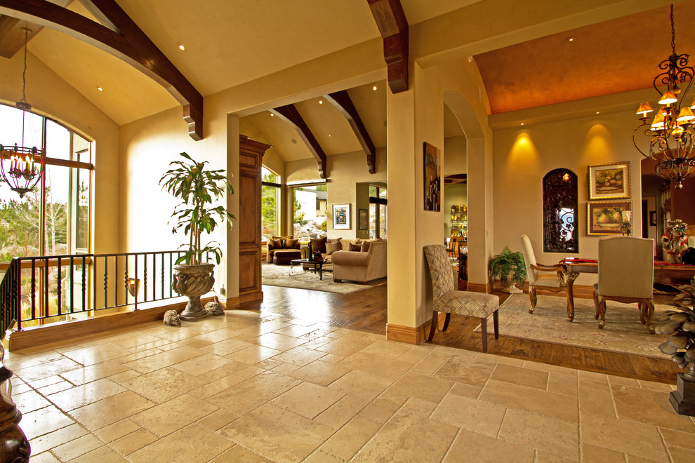 Design ideas for an expansive traditional foyer in Other with beige walls and travertine flooring.