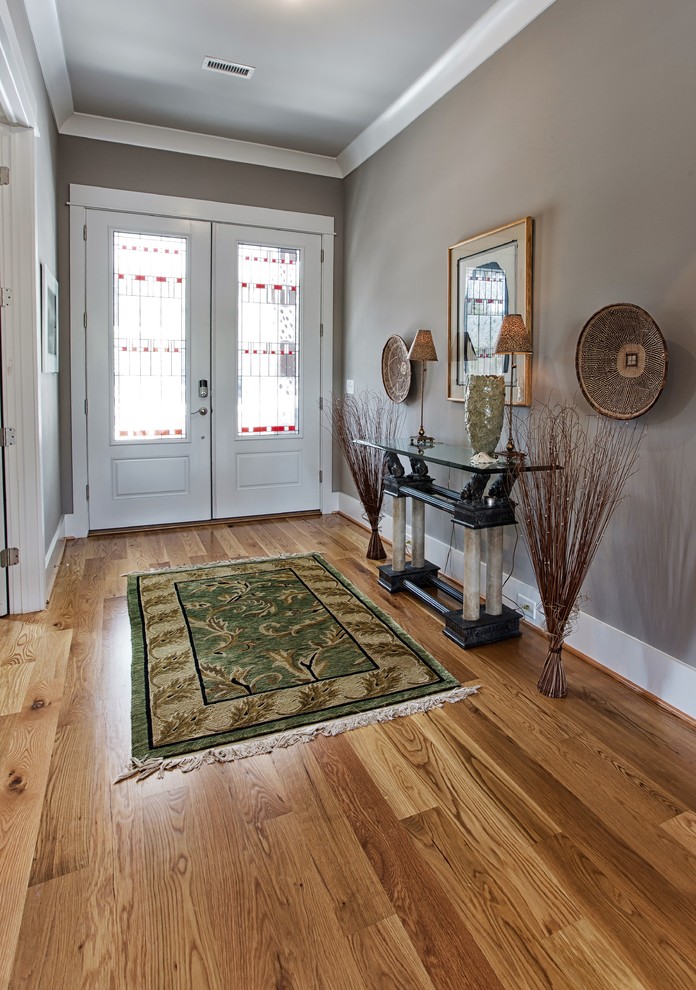 This is an example of a medium sized traditional foyer in Wilmington with light hardwood flooring, a double front door and a white front door.