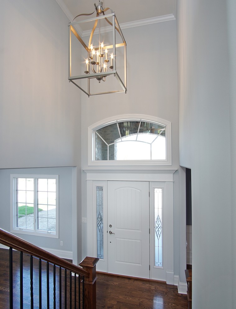 Пример оригинального дизайна: прихожая в стиле неоклассика (современная классика) с белыми стенами, паркетным полом среднего тона, одностворчатой входной дверью и белой входной дверью