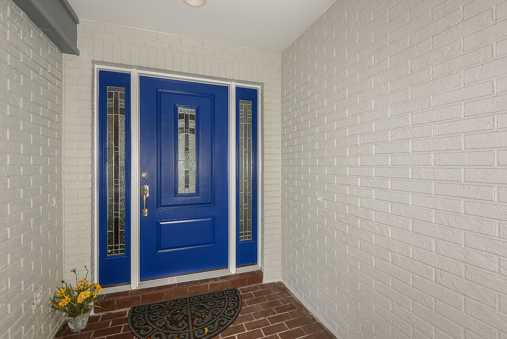 На фото: входная дверь среднего размера в современном стиле с серыми стенами, кирпичным полом, одностворчатой входной дверью и синей входной дверью с