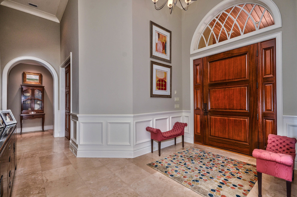 Example of a mid-sized transitional travertine floor entryway design in Tampa with gray walls and a medium wood front door
