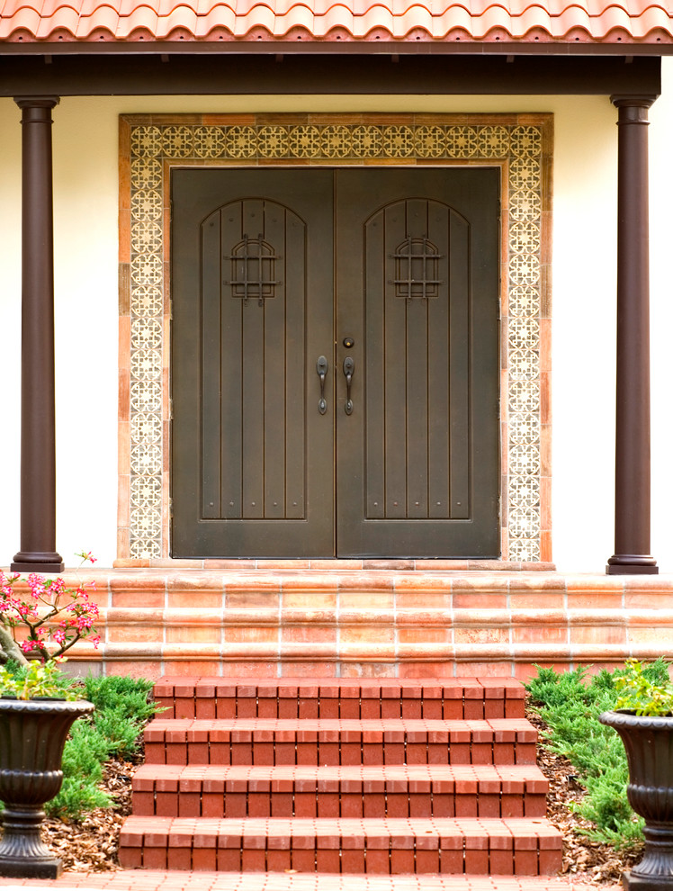 Esempio di una piccola porta d'ingresso mediterranea con pareti beige, una porta a due ante e una porta in legno scuro
