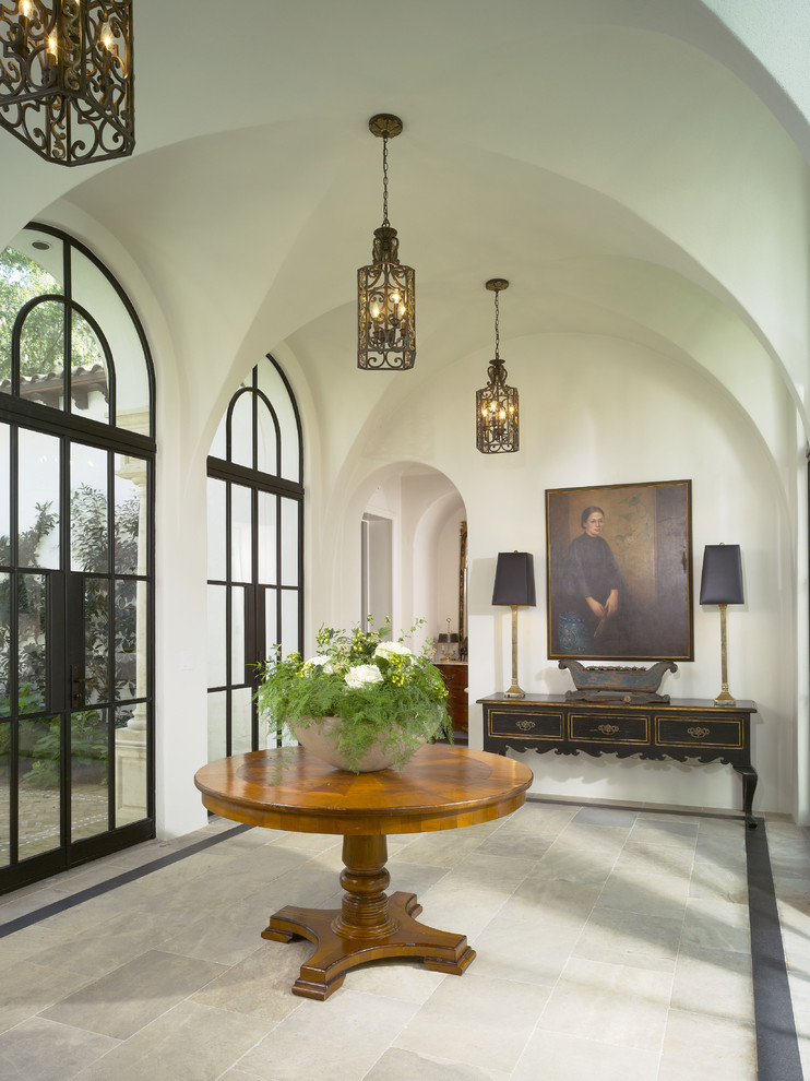 Design ideas for a mediterranean foyer in Atlanta with white walls, a double front door, a glass front door and feature lighting.