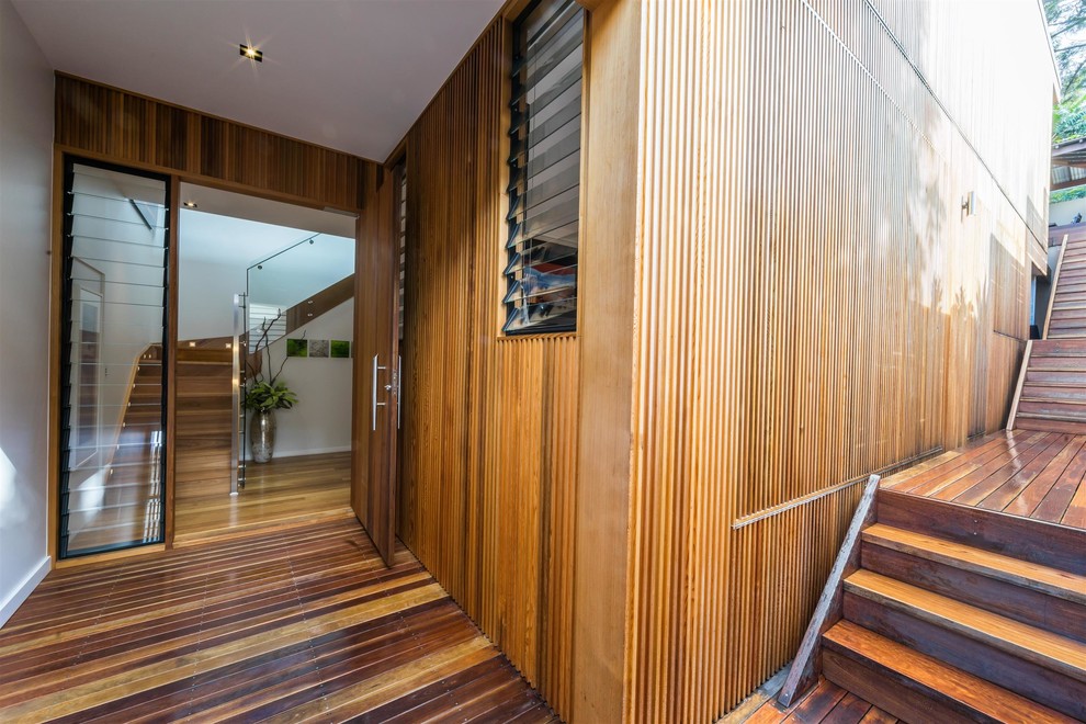 Inspiration for a medium sized contemporary front door in Brisbane with brown walls, medium hardwood flooring, a pivot front door, a medium wood front door and brown floors.