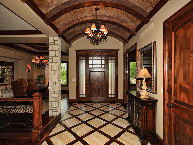 Entryway - large mediterranean dark wood floor entryway idea in Wichita with beige walls and a dark wood front door