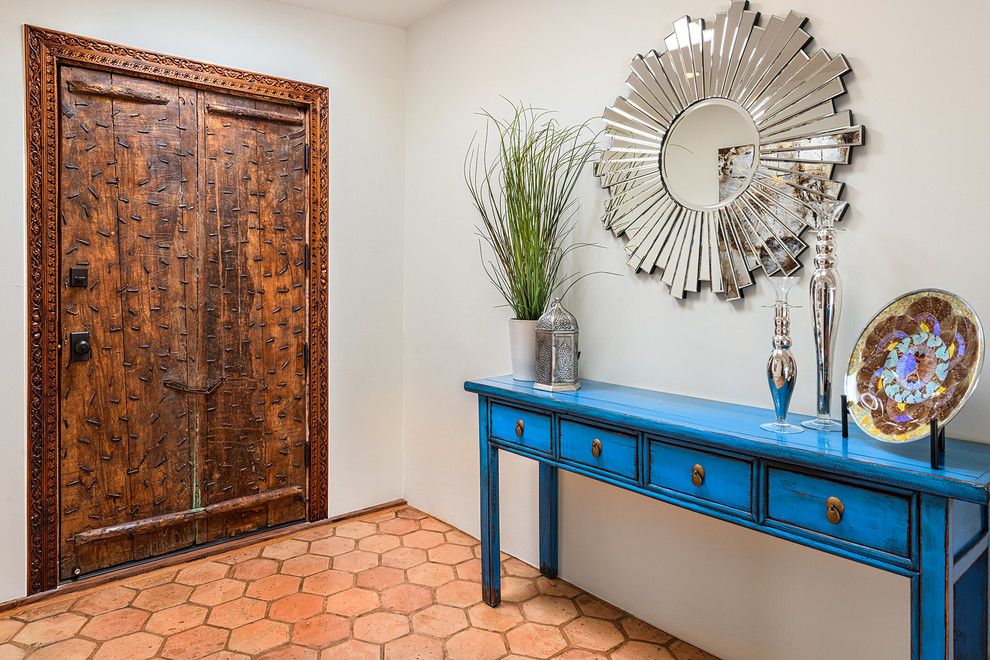 Ejemplo de entrada ecléctica con puerta doble, puerta de madera en tonos medios y suelo naranja