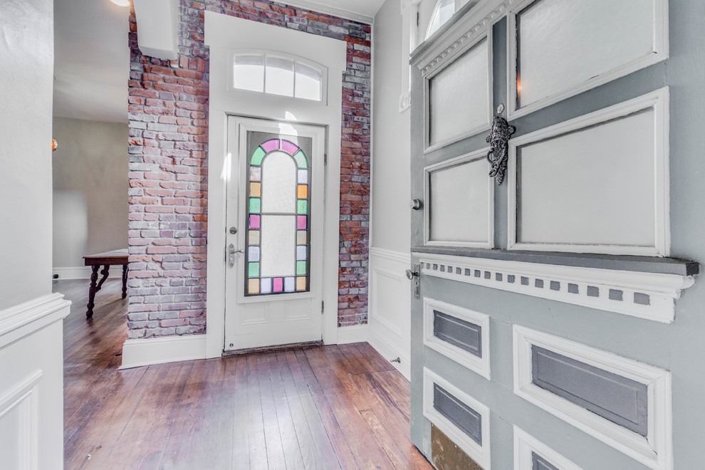 Foto på en stor vintage ingång och ytterdörr, med grå väggar, mörkt trägolv, en enkeldörr, en grön dörr och brunt golv