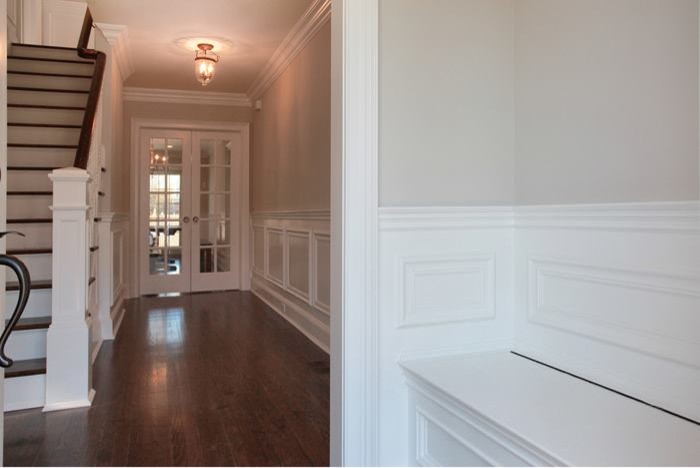 Mittelgroßes Klassisches Foyer mit beiger Wandfarbe, braunem Holzboden, Einzeltür und dunkler Holzhaustür in New York