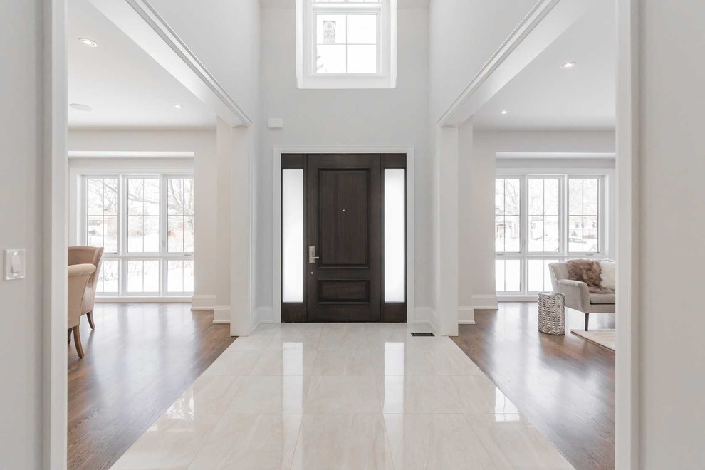 Inspiration för stora klassiska ingångspartier, med vita väggar, marmorgolv, en enkeldörr, en brun dörr och gult golv