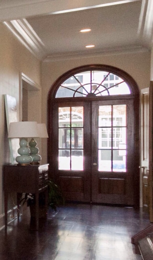 Imagen de puerta principal clásica renovada de tamaño medio con paredes beige, suelo de madera oscura, puerta doble y puerta de madera oscura