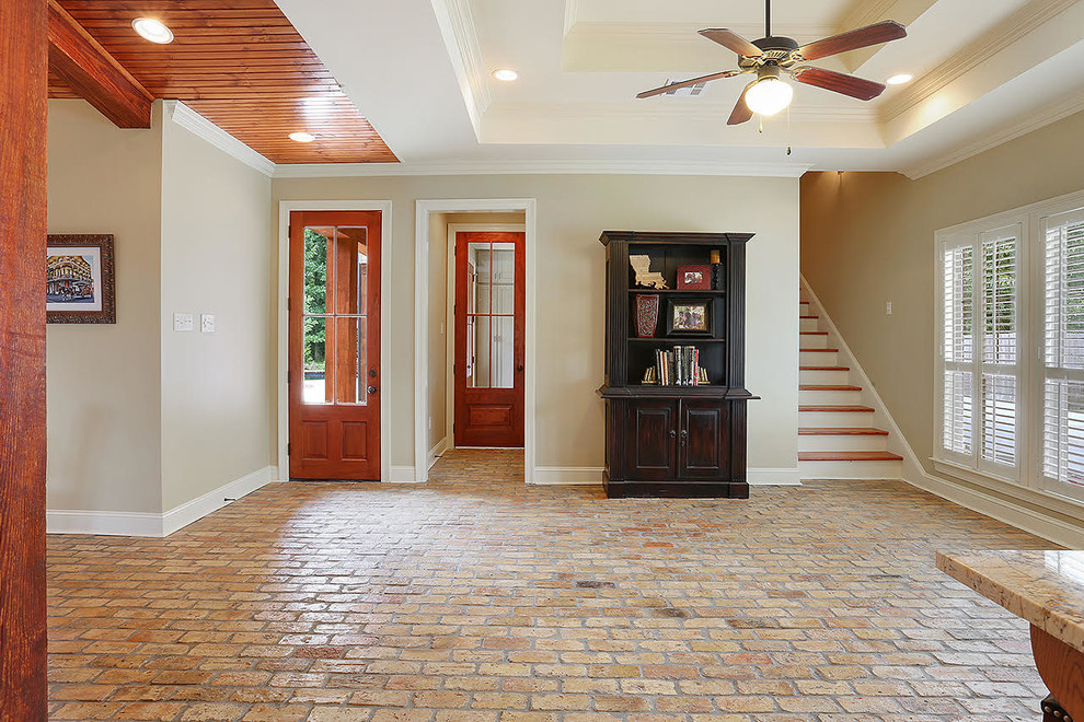 Cette photo montre un hall d'entrée chic de taille moyenne avec un mur beige, un sol en brique, une porte simple et une porte marron.