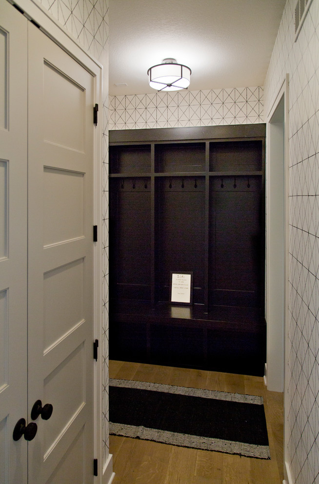 Exempel på ett mellanstort modernt kapprum, med flerfärgade väggar, ljust trägolv, en enkeldörr, en vit dörr och brunt golv