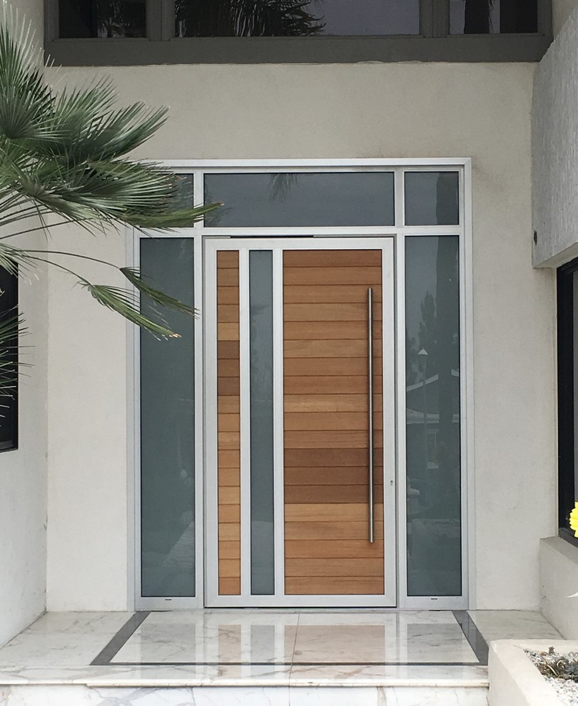 Aménagement d'une porte d'entrée moderne de taille moyenne avec une porte simple et une porte en bois clair.