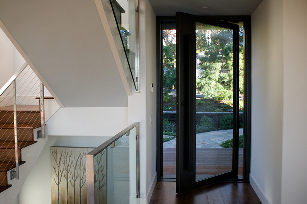 На фото: входная дверь в стиле модернизм с поворотной входной дверью и черной входной дверью с