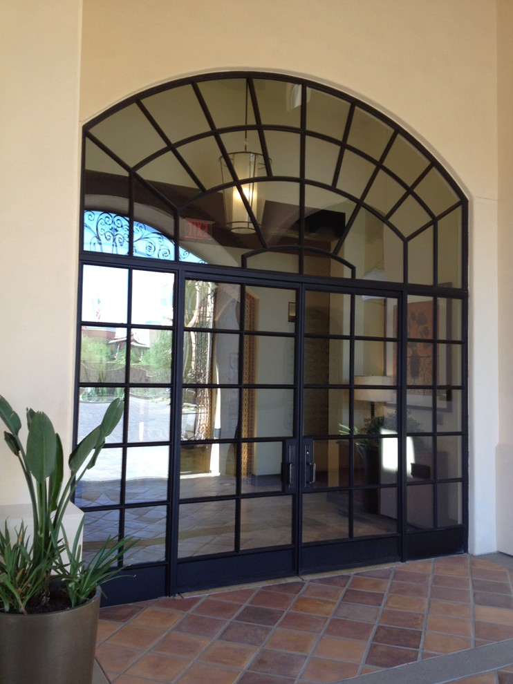 Esempio di una porta d'ingresso stile americano con una porta a due ante e una porta in vetro