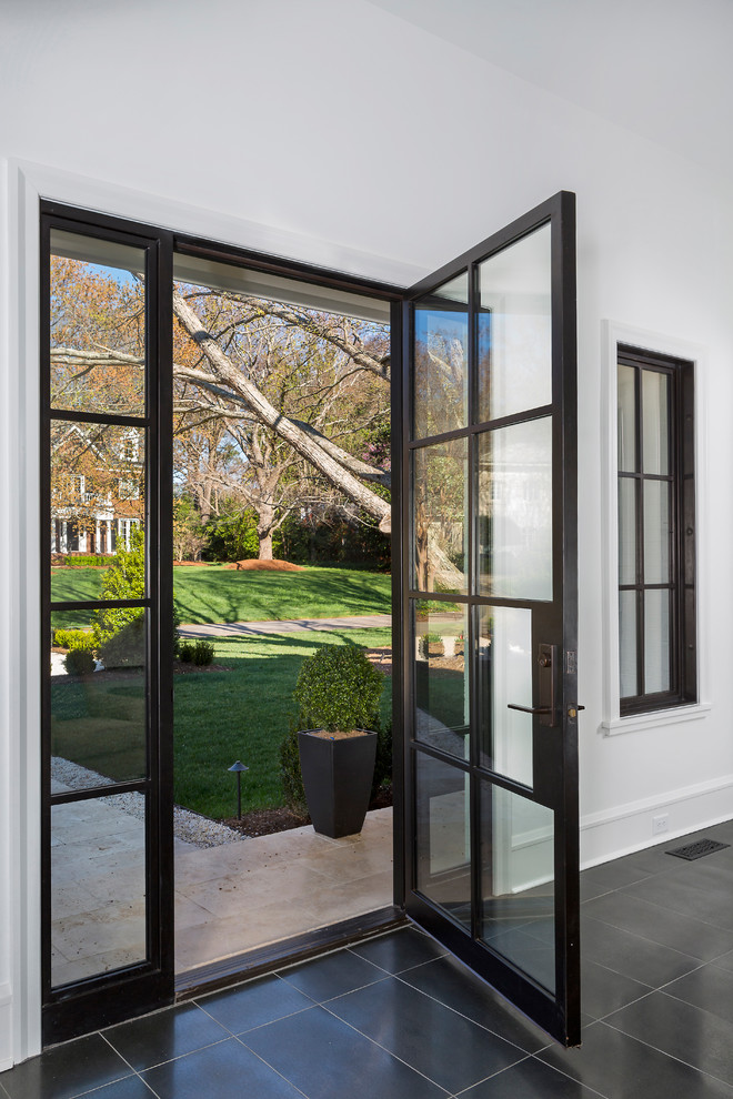 Photo of a contemporary front door in Charlotte with white walls, a single front door, a black front door and black floors.