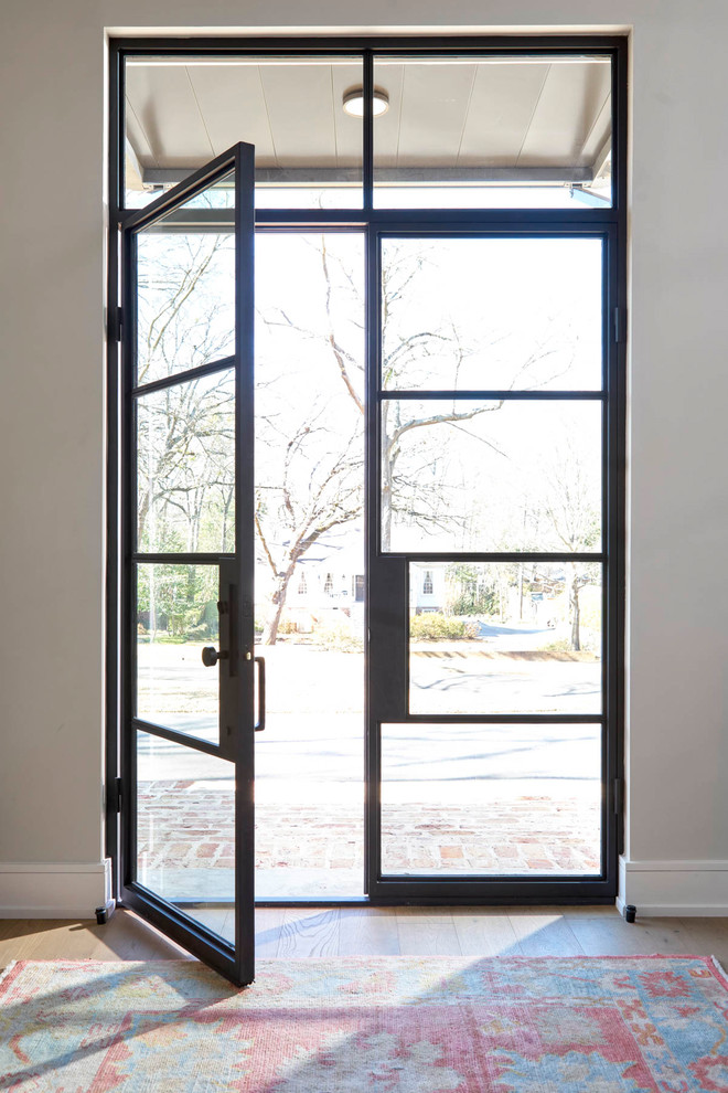 На фото: входная дверь среднего размера в современном стиле с двустворчатой входной дверью, серыми стенами, стеклянной входной дверью, светлым паркетным полом и коричневым полом с