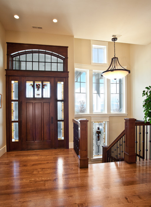 Foto de puerta principal tradicional de tamaño medio con paredes beige, suelo de madera en tonos medios, puerta simple y puerta de madera oscura