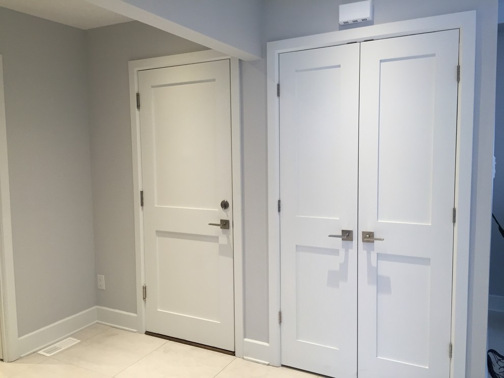This is an example of a classic entrance in Montreal with grey walls, a single front door and a white front door.