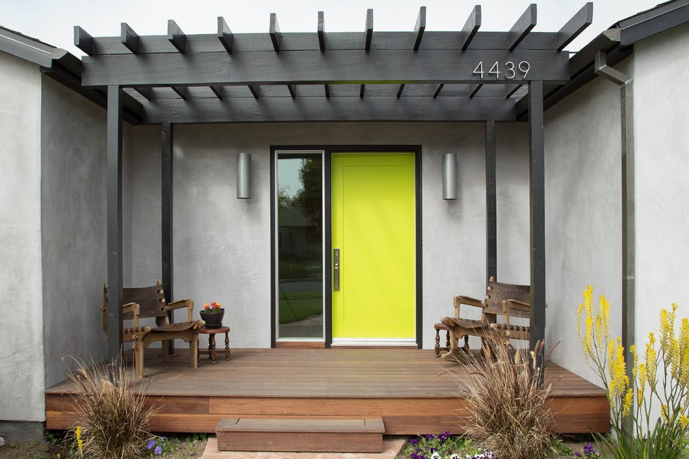 Modern inredning av en entré, med en enkeldörr och en grön dörr