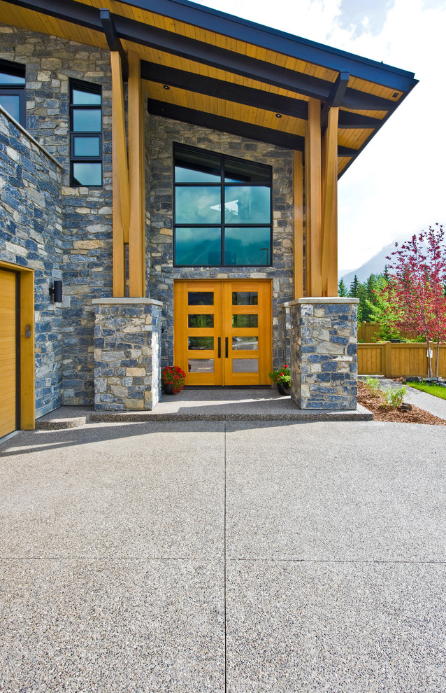 Example of a mountain style entryway design in Calgary with a glass front door