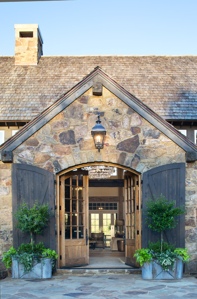 Пример оригинального дизайна: прихожая в стиле кантри с коричневыми стенами, полом из известняка, двустворчатой входной дверью, входной дверью из дерева среднего тона и коричневым полом
